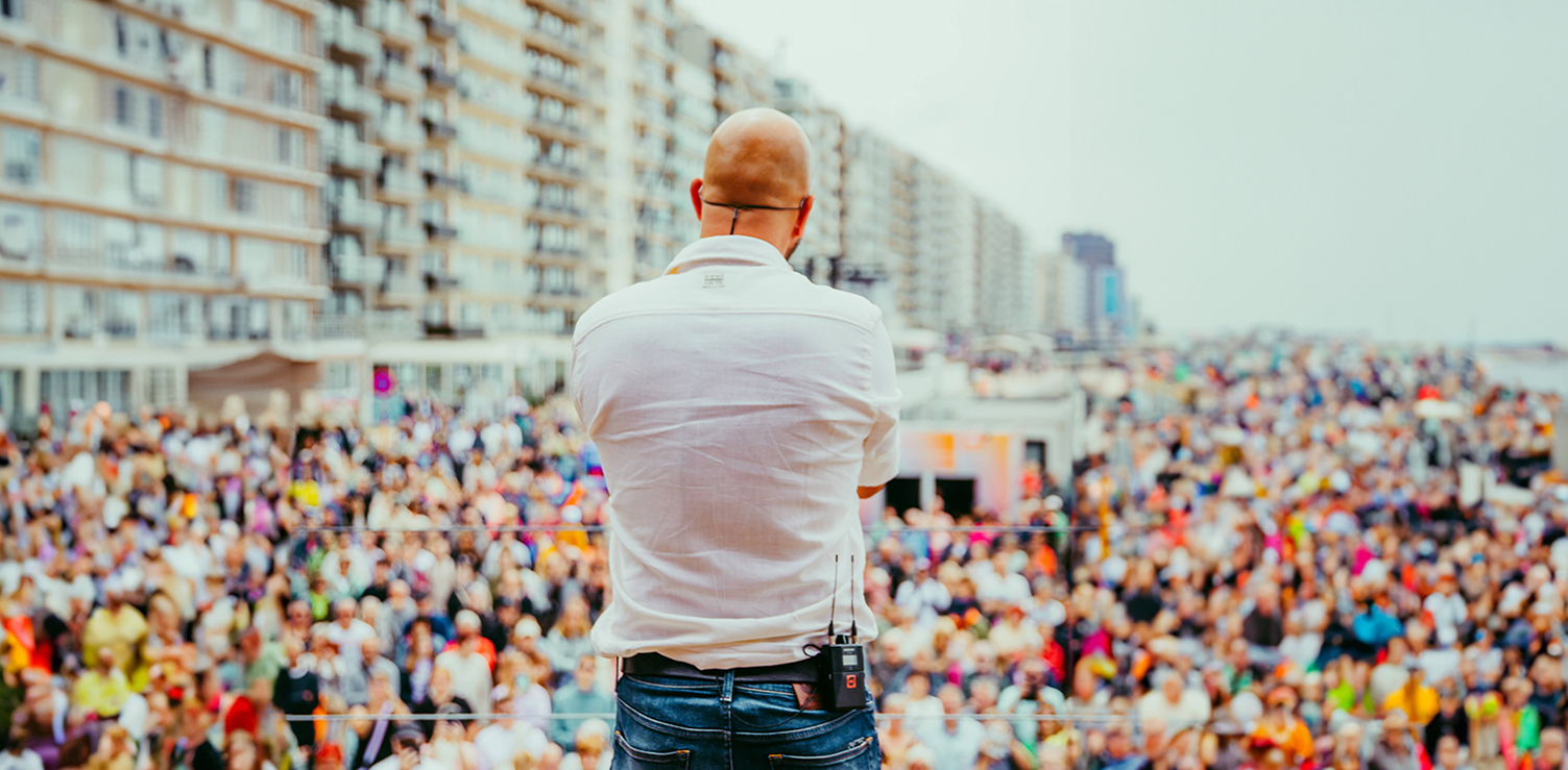 Stan Van Samang brengt een live-optreden op het dak van de pop-upstudio van Radio2 in Blankenberge met het publiek op de dijk op de achtergrond