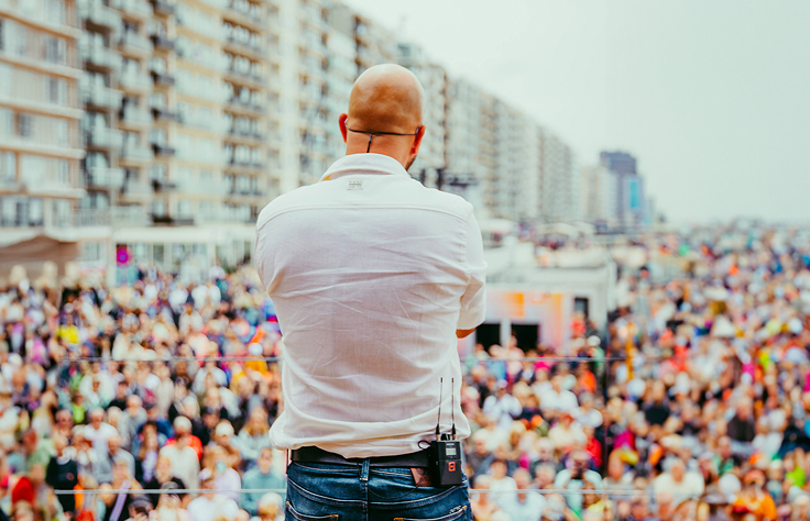 Stan Van Samang brengt een live-optreden op het dak van de pop-upstudio van Radio2 in Blankenberge met het publiek op de dijk op de achtergrond