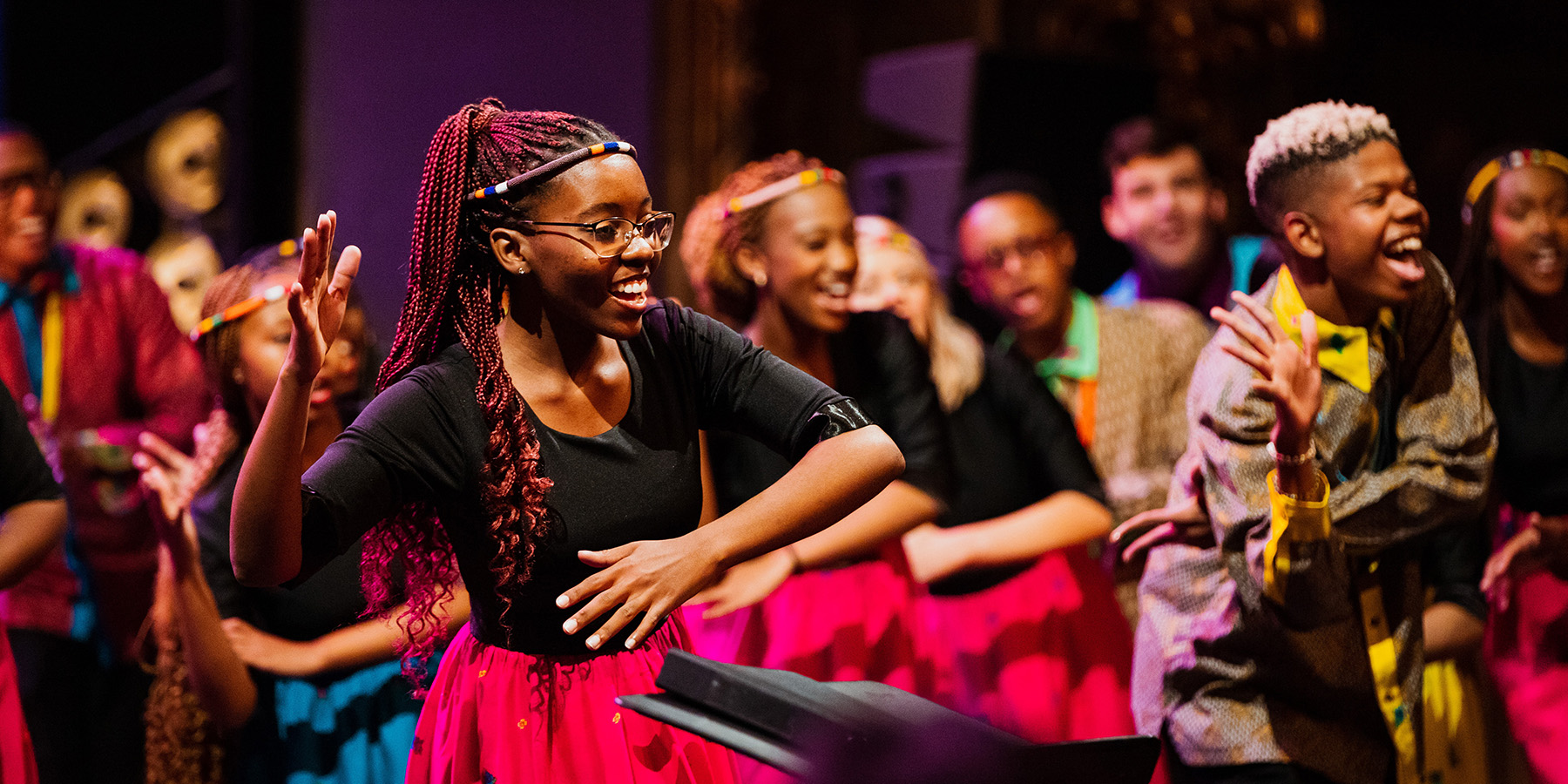 Solozangeres van UP Youth Choir danst en zingt vooraan op het podium van de Bourlaschouwburg
